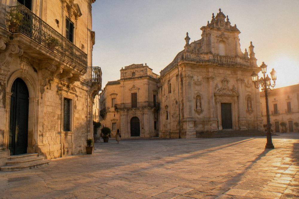 Empty golden square in Lecce in warm late afternoon light with long shadows