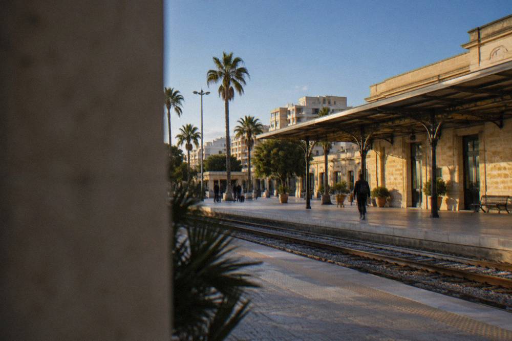 A small regional airport terminal building under a blue sky in southern Italy
