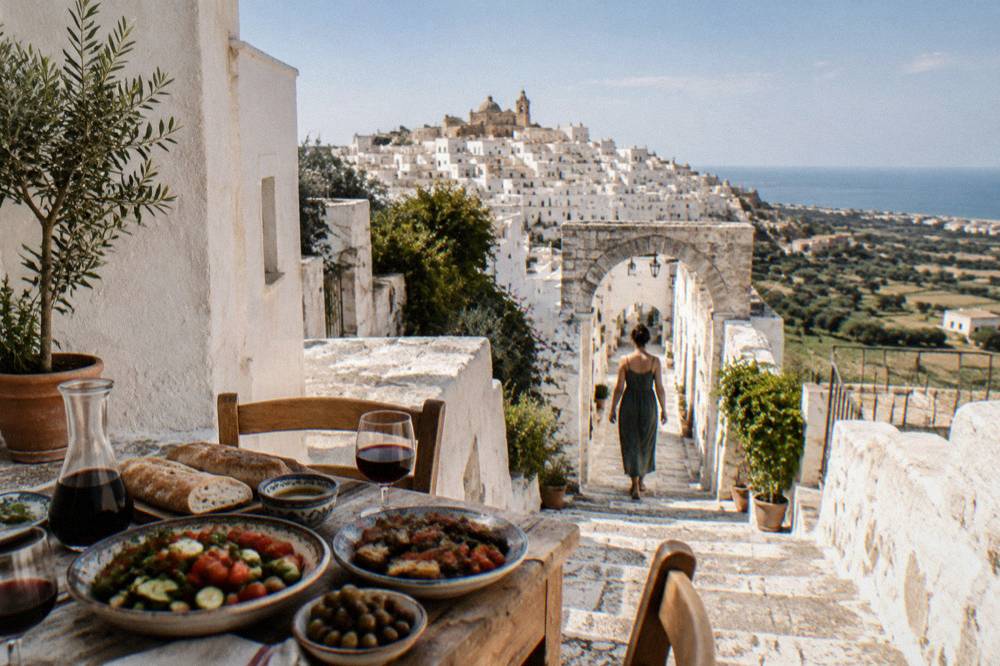 A rustic Salento lunch table with vegetables, bread and wine in a family home