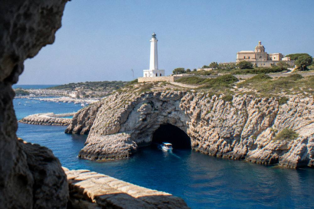 A small boat entering a sea cave on the cliffs near Santa Maria di Leuca