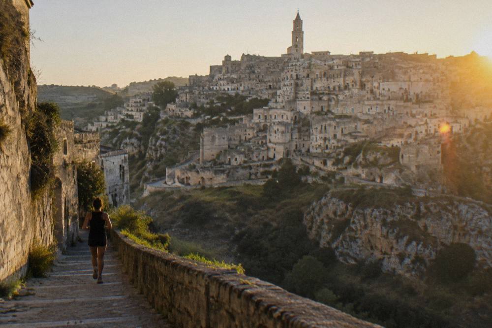A limestone cave dwelling district of Matera seen from across the ravine at golden hour