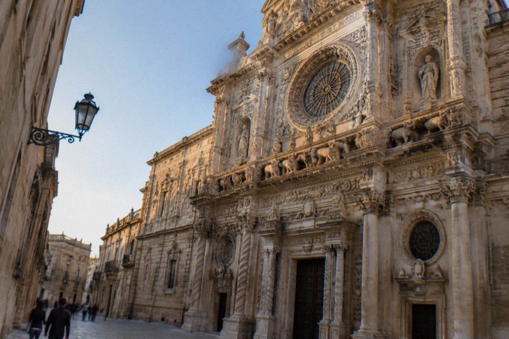 The densely carved limestone facade of the Basilica di Santa Croce in Lecce