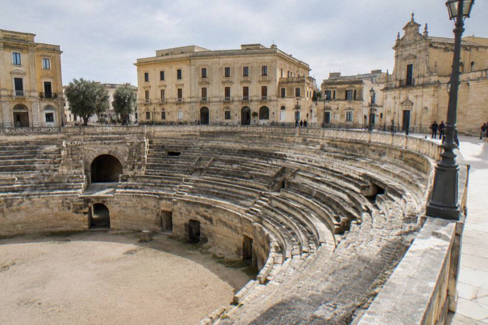 The sunken Roman amphitheatre in Lecce seen from street level with the square around it