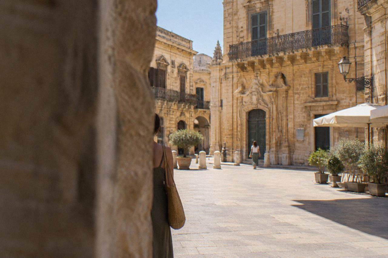 Honey-coloured baroque facades around a sunlit square in Lecce old town