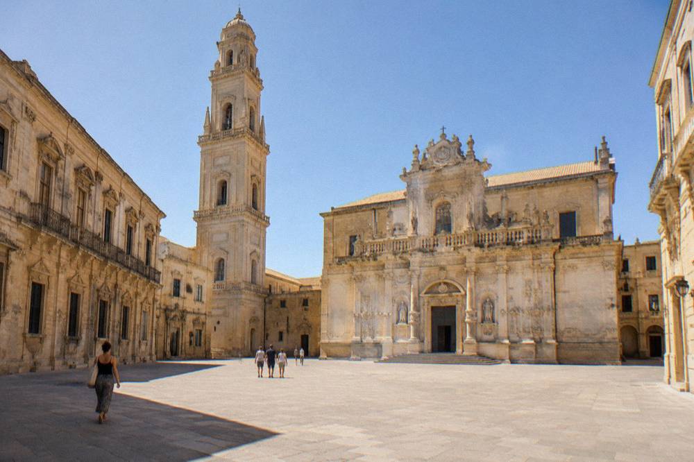 The layered baroque facade of Lecce Cathedral seen across Piazza del Duomo