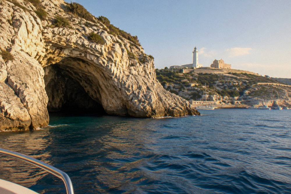 A limestone sea cave entrance on the coast near Santa Maria di Leuca seen from a small boat