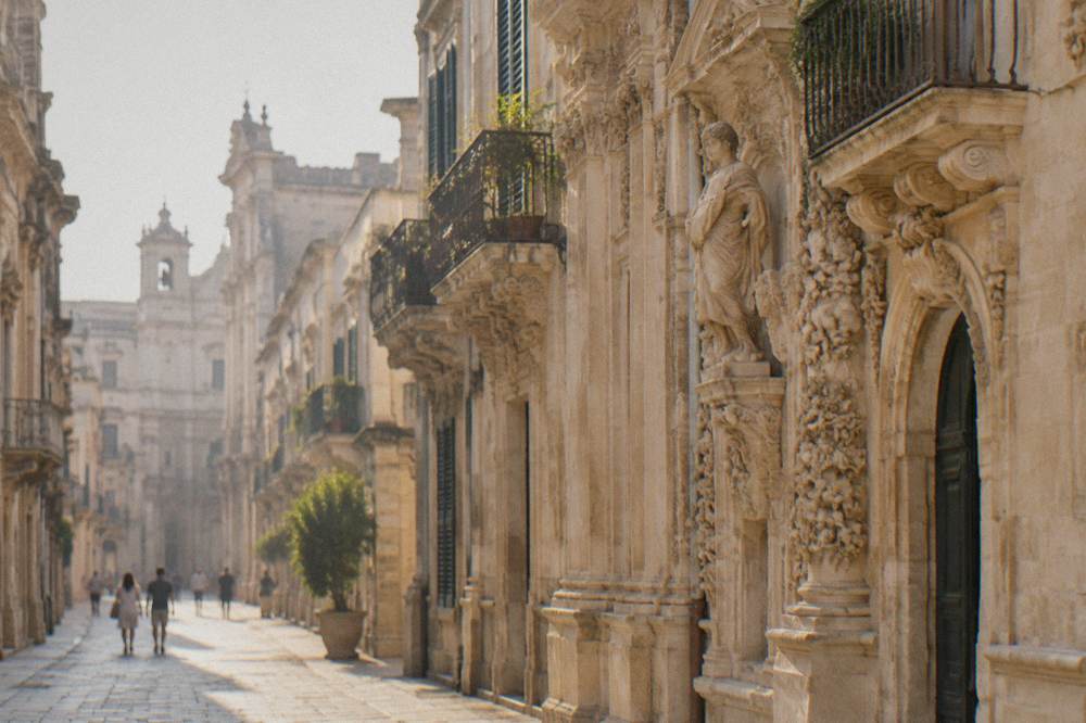 A baroque limestone facade in Lecce carved with flowers and figures in warm evening light