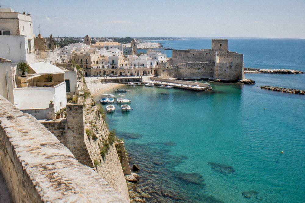 White-washed houses above the turquoise sea at Otranto with a stone rampart