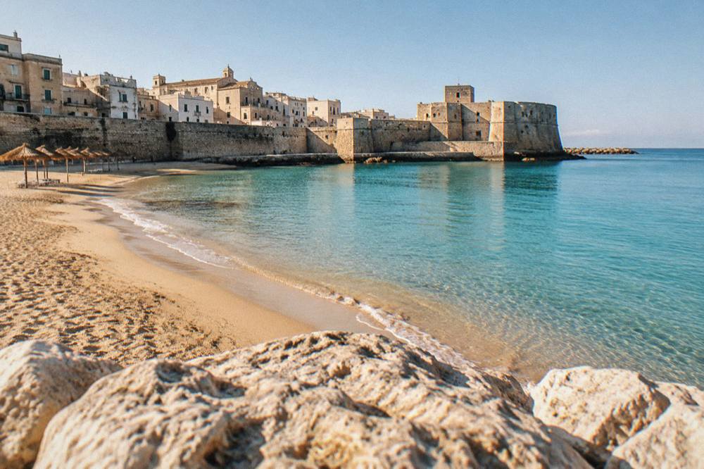 An empty golden beach in Salento in early morning light with calm sea